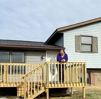 woman standing on deck looks over her yard