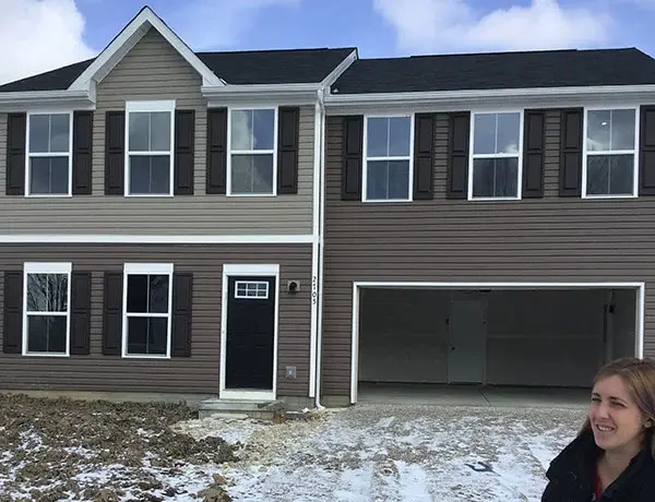 A woman standing in front of her dream home 